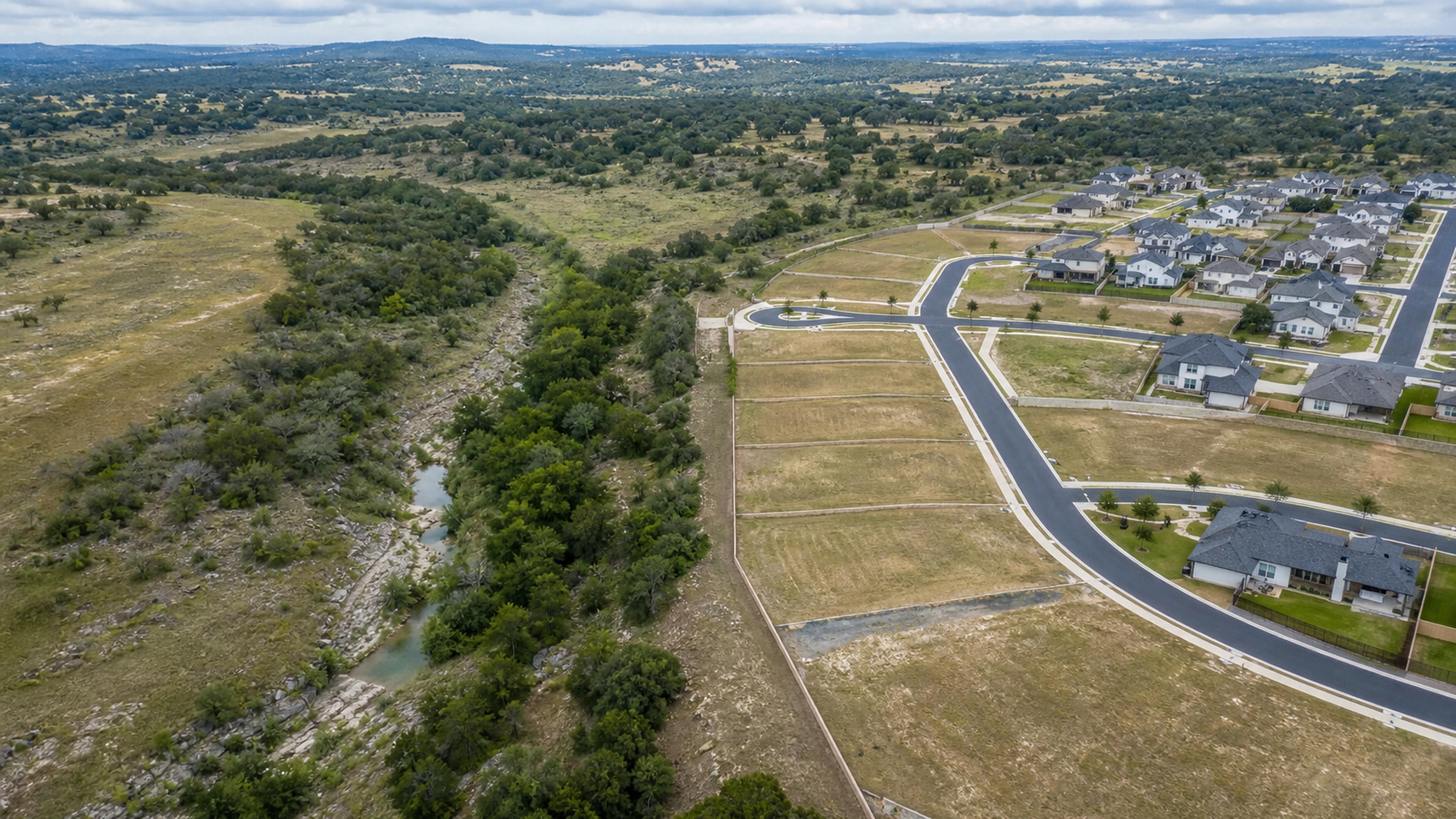 Serviced home lots beside a preserved creek and completed neighborhood in central Texas